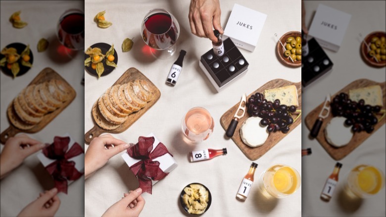 A party table with cheese and bread and jukes cordialities in bottles and mixed into wine glasses