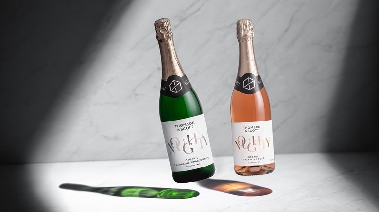 Bottles of Noughty sparkling wines floating above a marble surface