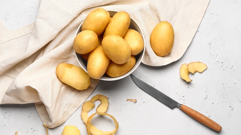 Potatoes in bowl and on board