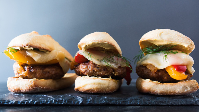 Three burgers with peppers