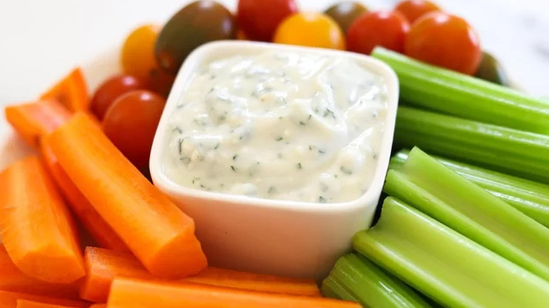 Blue cheese dip in small dish surrounded by chopped vegetables