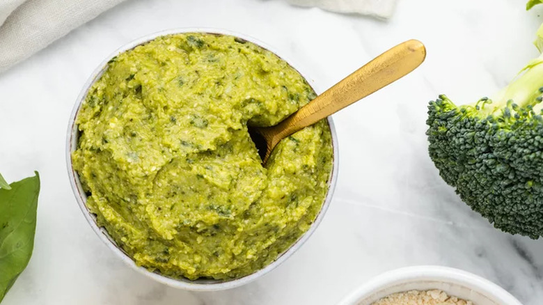 Bowl of broccoli pesto with wooden spoon