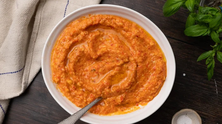 Bowl of bright romesco sauce with spoon