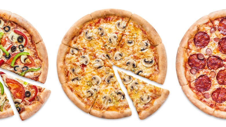 Several pizza pies against white