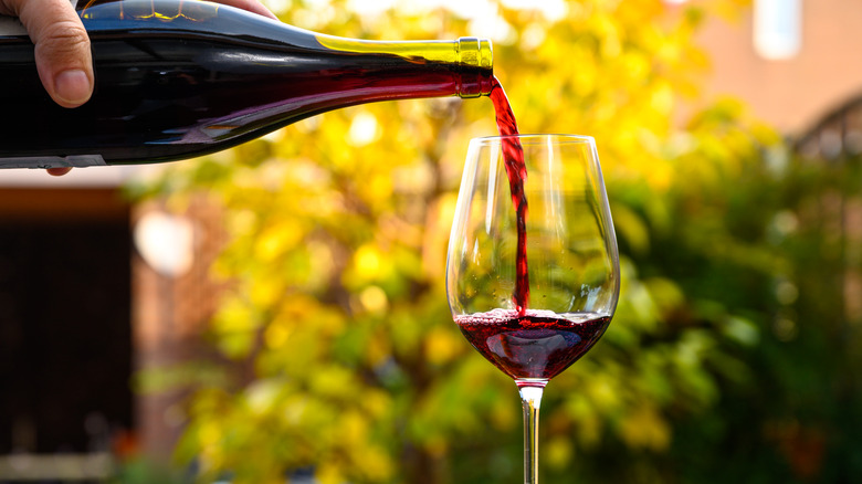 Pouring light red wine into glass