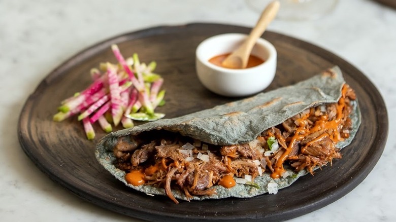 An empanada on wooden plate