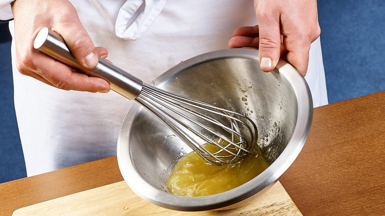 chef whisking gravy in bowl