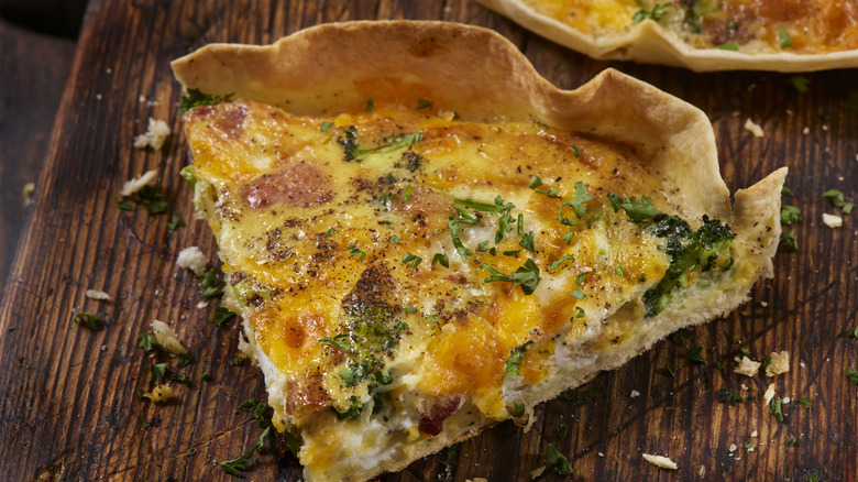 Quiche slice on wooden surface