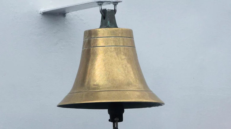 Brass bell hanging from wall