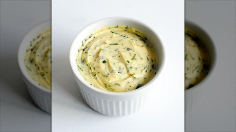 herb butter in white dish on white backdrop