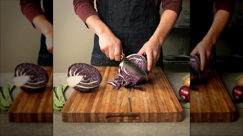 Person chopping vegetable on Teakhaus cutting board