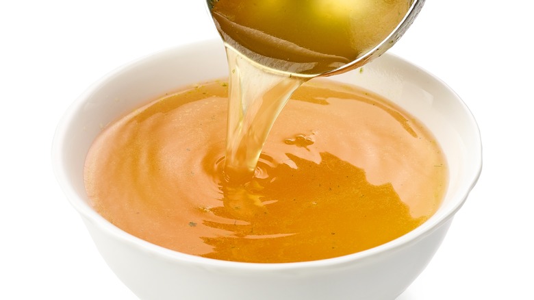 Pouring chicken broth into bowl