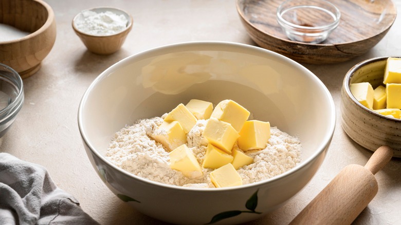 Flour and butter in bowl on table