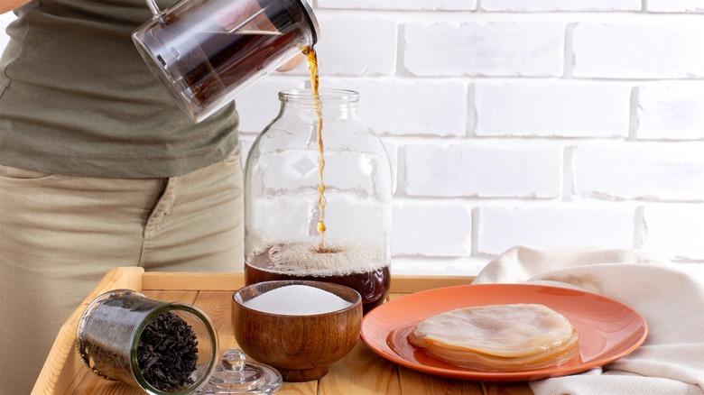 Pouring kombucha tea into jar