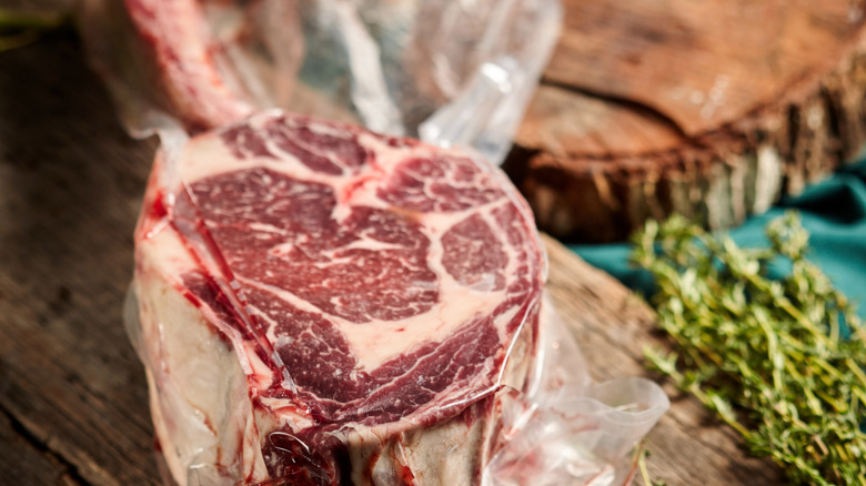 Steak resting in plastic wrap