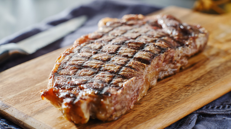 Cooked steak resting on board