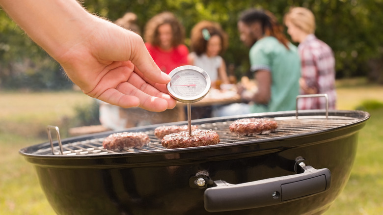 Checking meat temperature on grill