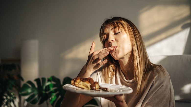 Happy woman eating chocolate