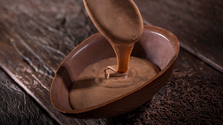 Pouring chocolate into egg 