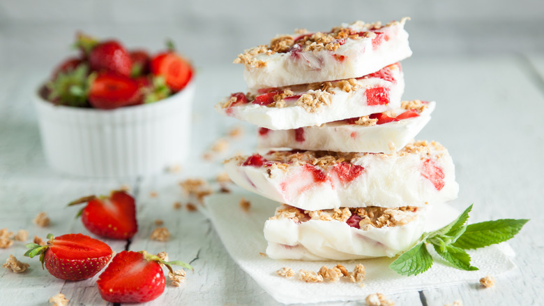 Stacked yogurt bark next to strawberries