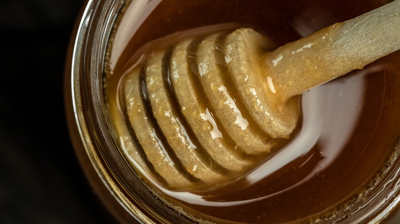 Honey in jar with stick