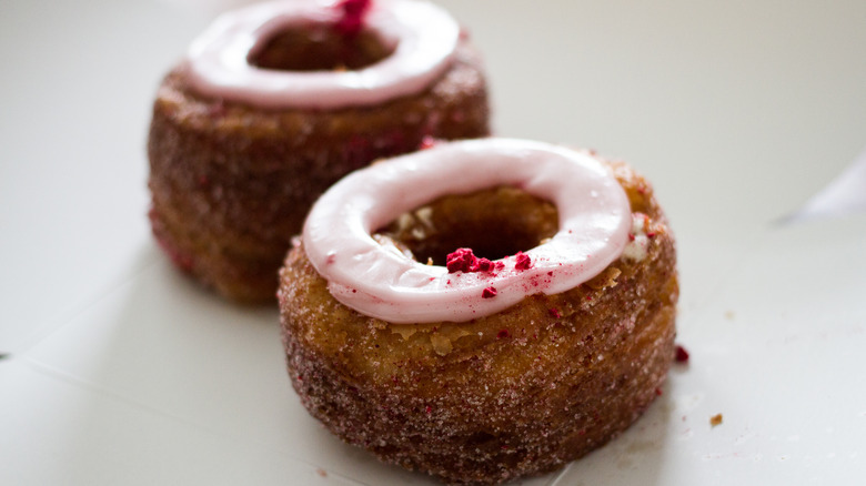 Two cronuts on white counter