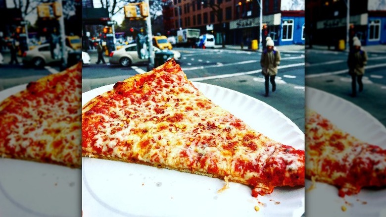 Pizza slice on paper plate