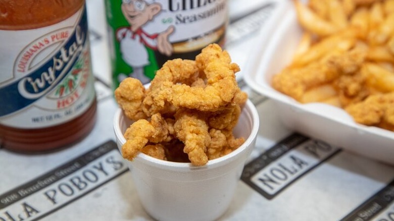 Styrofoam cup of fried food on NOLA Poboys wrap paper