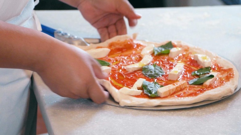 Hands making fresh pizza