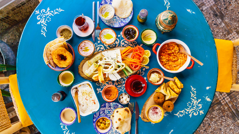 Assortment of plated foods and dips on blue table