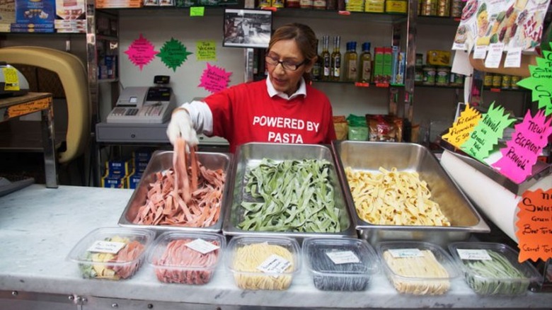 Woman working pasta food stand in New York