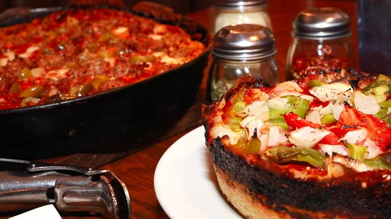 Two Chicago deep dish pizzas on wooden table