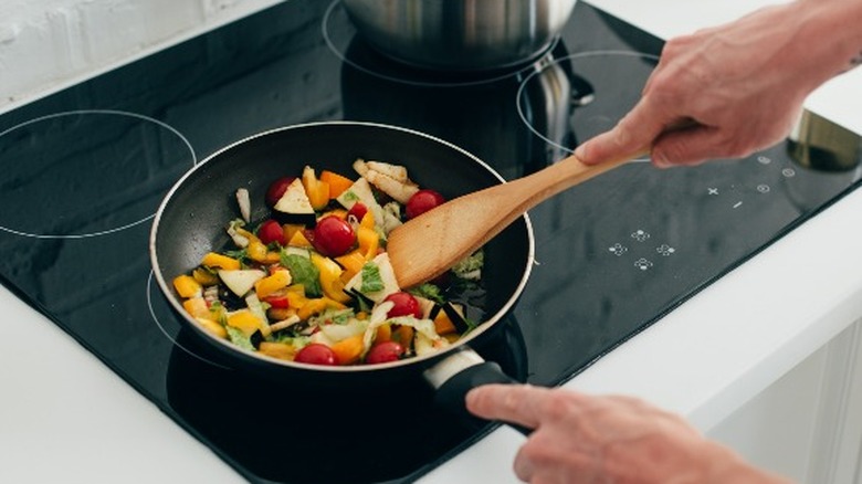 man cooking vegetables on stovetop