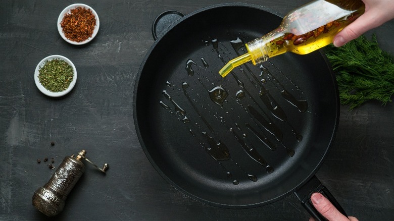 woman pouring oil into pan