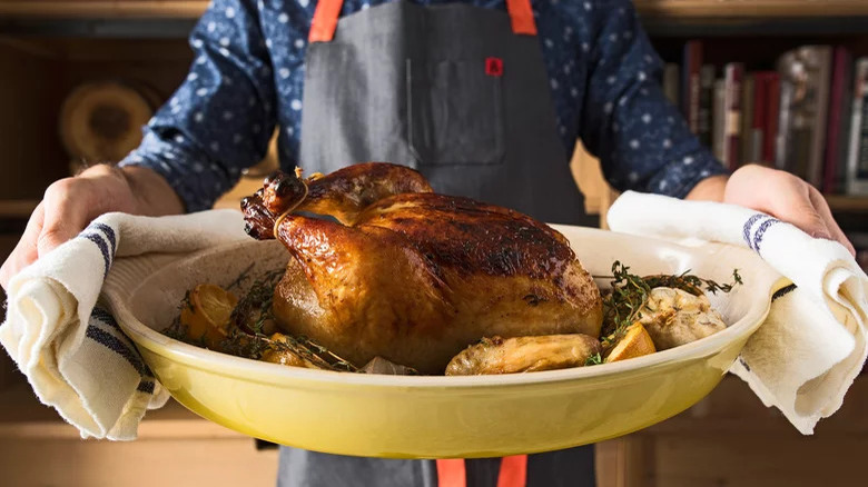 person holding roast chicken tray