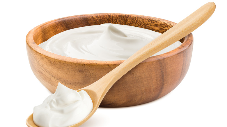 Sour cream in wooden bowl