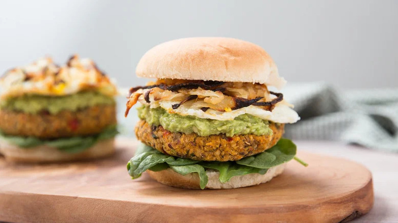 Avocado Toast-Inspired Veggie Brunch Burger on wooden cutting board