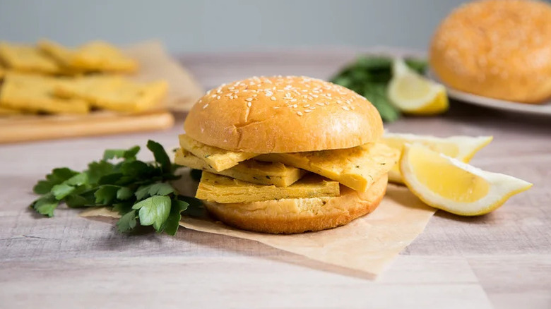 Baked Panelle Sandwich on parchment paper with lemon slices