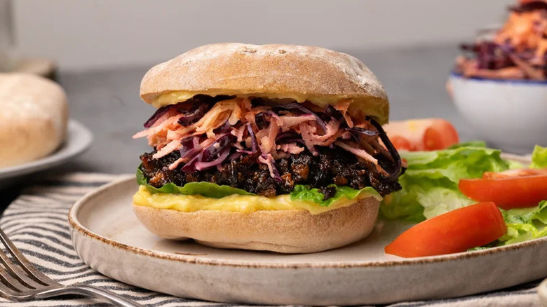 BBQ Mushroom Sandwich with Carrot-Apple Slaw and Homemade Aioli on white plate with side salad