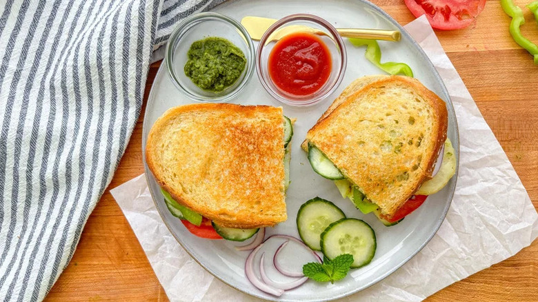 Golden Bombay Sandwich with Cilantro-Mint Chutney on white plate with condiments