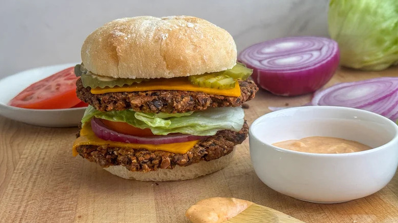 The Ultimate Vegan Smash Burger on cutting board with condiments