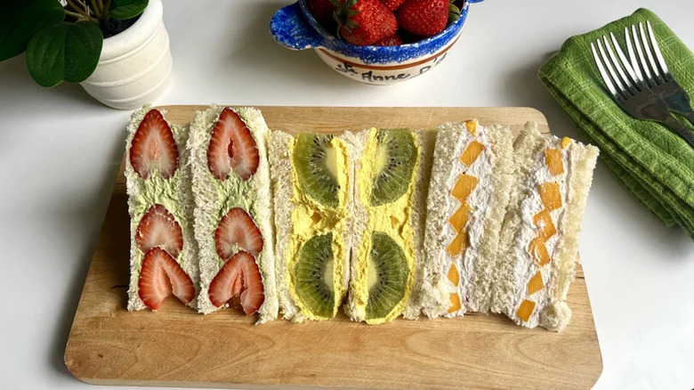 Trio of Colorful Japanese Fruit Sandwiches on wooden cutting board