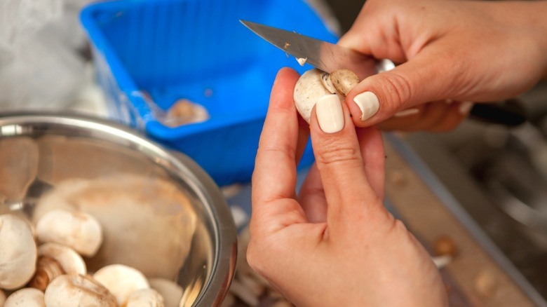 woman cutting mushroom stems off