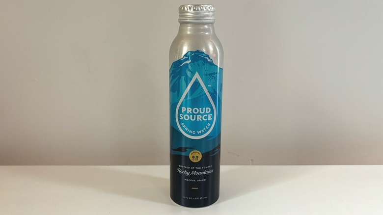 blue bottle of proud source water on table