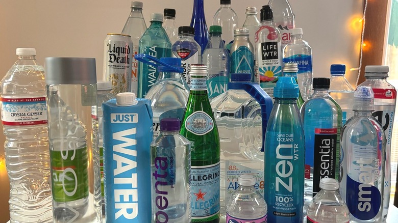 29 water bottles from different brands crowded on table