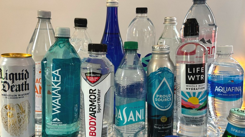 different brands of water bottles in rows on table