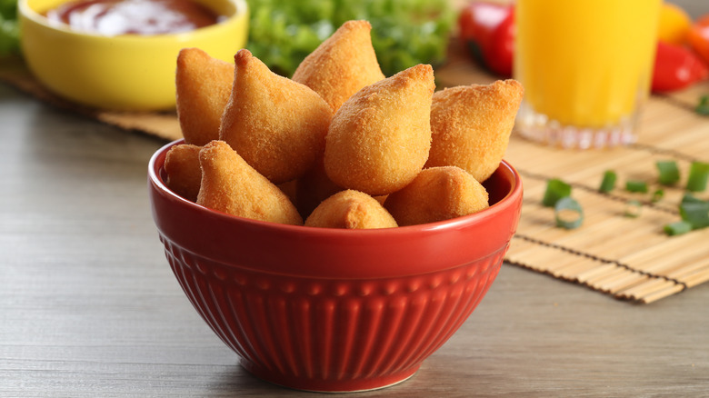 Bowl of coxinhas with ingredients in background