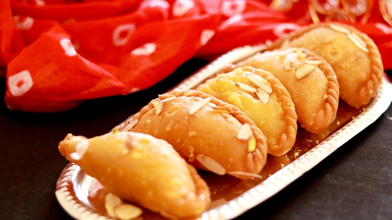 Gujiya on plate with traditional Indian fabric