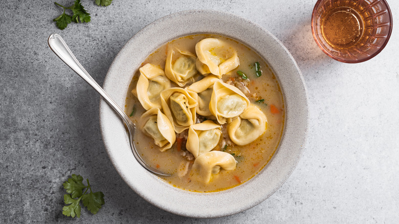 Tortellini in bowl of soup with a spoon inside