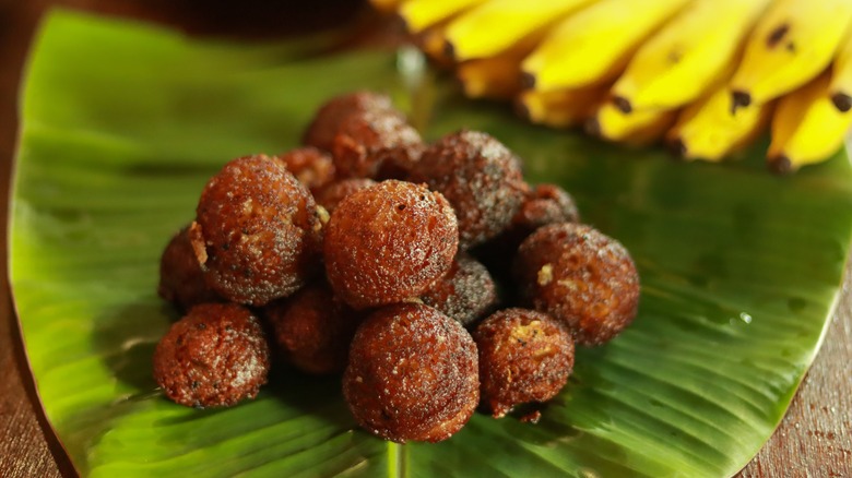 Mound of unniyappam on banana leaf with bananas